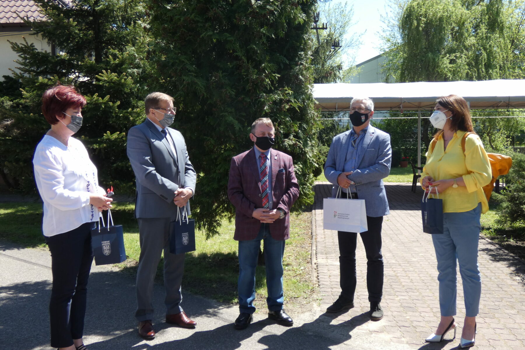 Darczyńcy wraz z przedstawicielami DPS na zdjęciu grupowym w maskach.