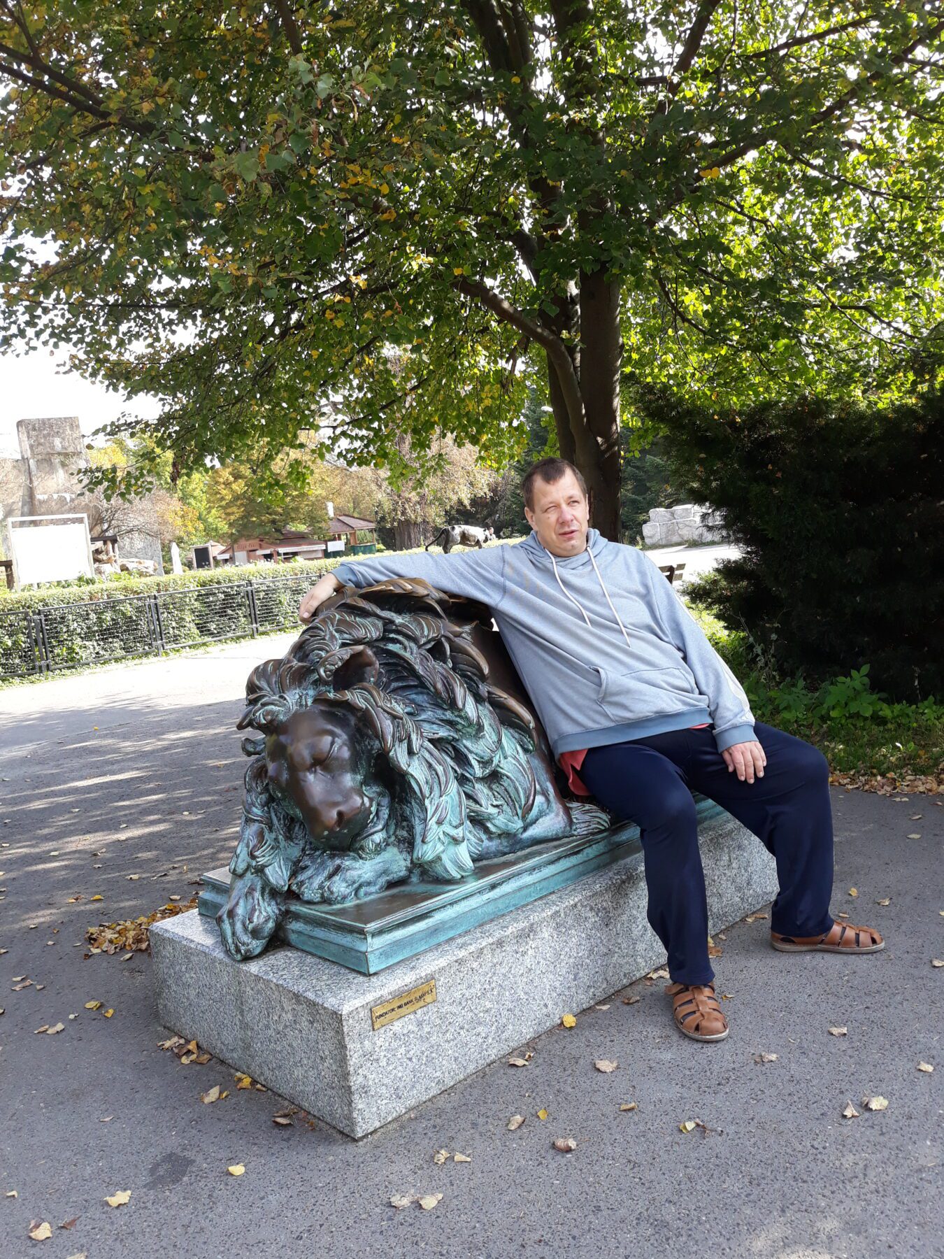 Mieszkaniec na zdjęciu z posągiem lwa.